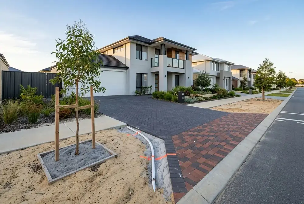 Charcoal herringbone driveway and crossover at a new home on grey sand in Ellenbrook, Perth by IBP Paving