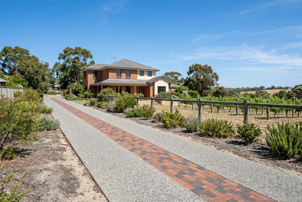 Paved acreage driveway on brown clay and grey sand at a Henley Brook rural property