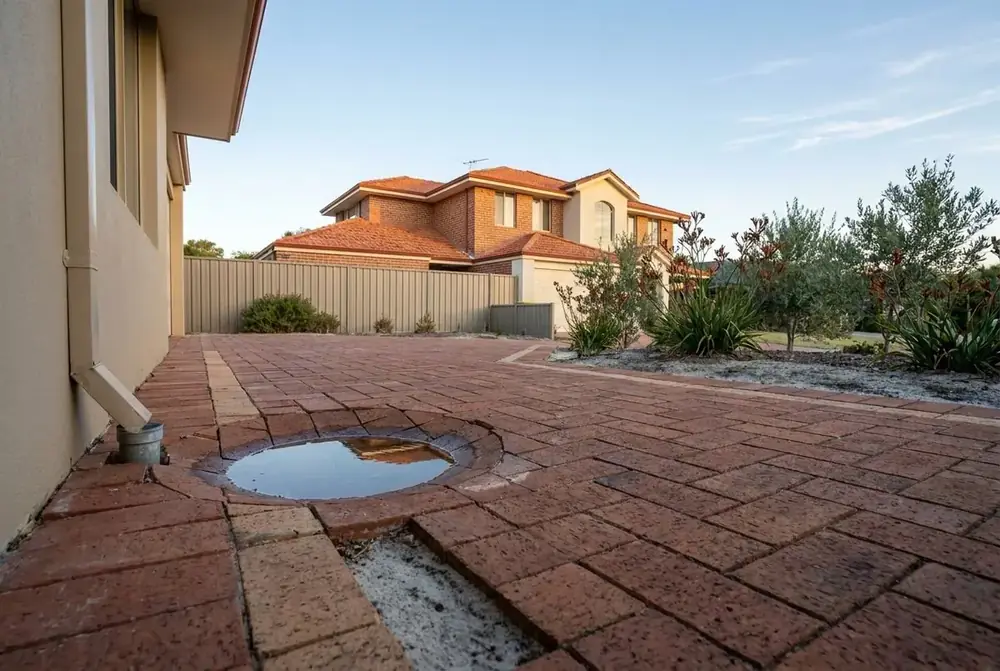 Sunken brick paving driveway with pooling water in Landsdale, Perth by IBP Paving