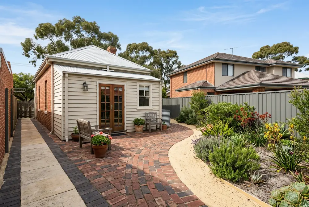 Clay brick courtyard behind an 1890s cottage on pale sand in Victoria Park
