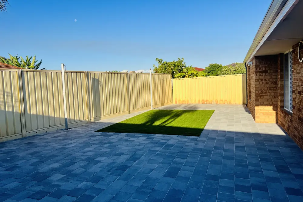 Backyard landscaping with charcoal paving and artificial turf in Perth by IBP Paving